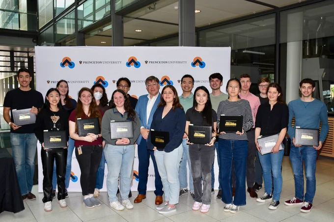 Full-color image of a group of grad students standing together in Frick Lab, holding their certificates.