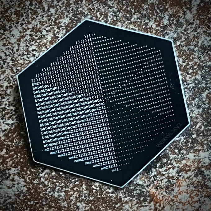 Closeup of the Nexus logo sticker: the hexagonal logo's "pie slices" is carried out via ASCII art: ranging from ZZZ, to bbb, to ), to asterisks, to carets (^), to periods, so that the logo is properly shaded.  Super cool!