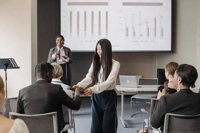Participants in a business seminar engage in an interactive Q&A session indoors, enhancing communication.