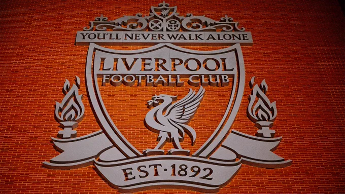 A photo of the LFC crest on the side of Anfield.