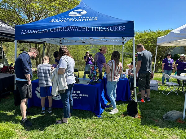 People stand under a tent at an outdoor outreach event.

Credit: Shannon Ricles/NOAA
