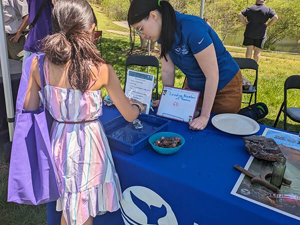 A woman helps a young girl learn about various shipwreck artifacts displayed on a table.

Credit: Jessica Frayser/NOAA