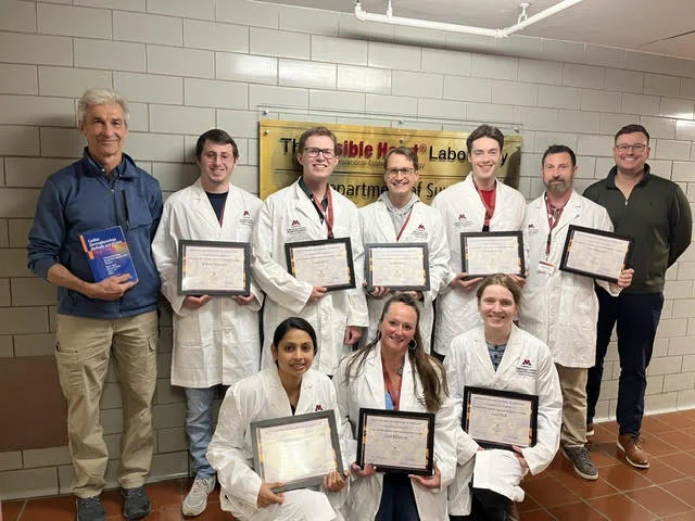 Group standing with completion certificates in the hall of the V-H-L.