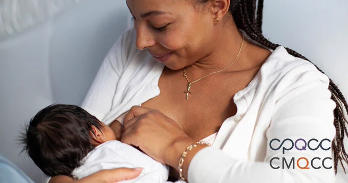 A parent breastfeeding their newborn baby.