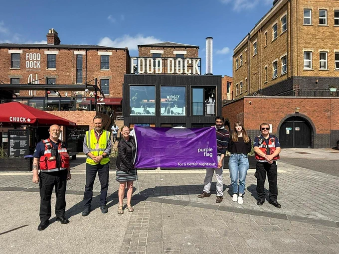 Local representatives of the city celebrate the purple flag award in front of Gloucester Food Dock.