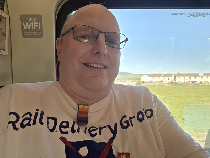 A picture of a relieved- looking me on a train, with my back to a window. 
My T-shirt says "rail delivery group"