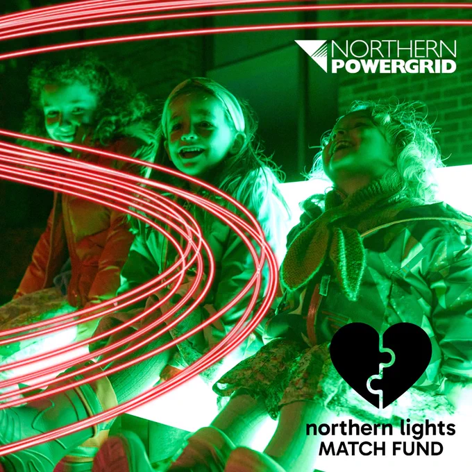 Three girls sitting on an illuminated seat at Durham Lumiere light art festival. The Northern Powergrid and Northern Lights match fund logos are on the graphic to depict the partnership. A red neon swish is overlaid on the photograph to represent electricity.