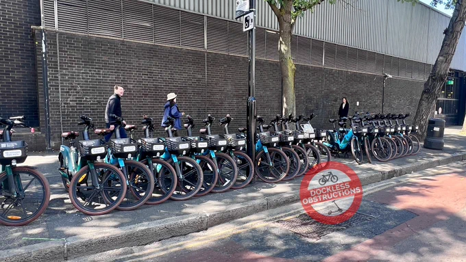 Long line of forest hire e-bikes deployed along pavement at Euston.