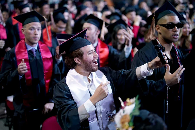 A graduate takes a selfie during commencement