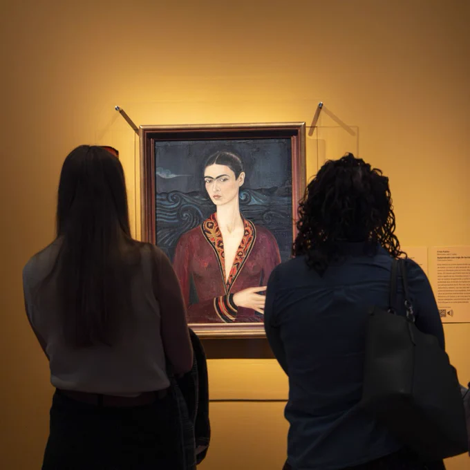 Two museum visitors view a portrait of Frida Kahlo in VMFA's special exhibition "Frida: Beyond the Myth."