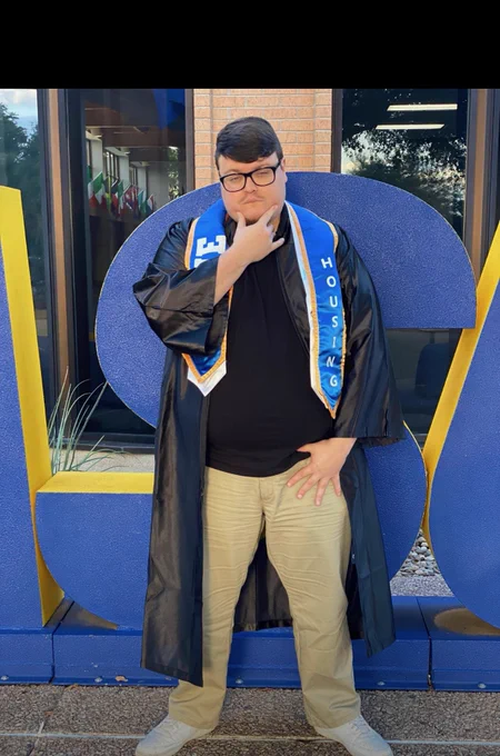 Angelo State Housing Student staff posing with their cap and gown.