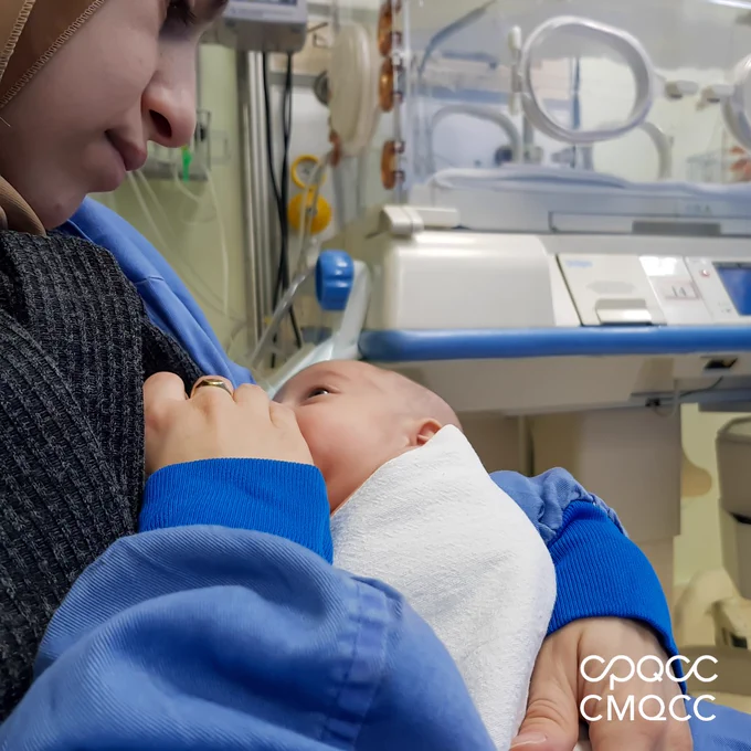 A NICU baby is breastfed by its parent in the neonatal ICU.