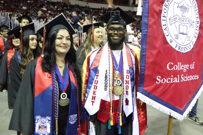 Graduating Sociology honors students Elizabeth Hernández and Jason Raythell Davis lead the Sociology Department Graduates at the processional before the commencement ceremony.