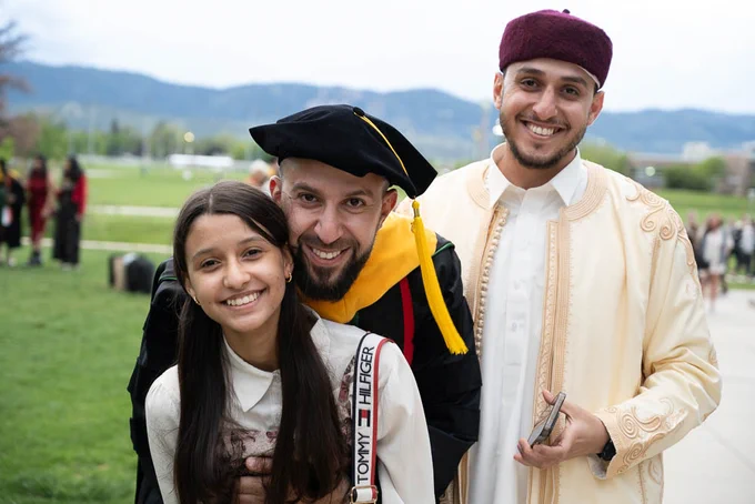 Graduate hugs a child and smiles.