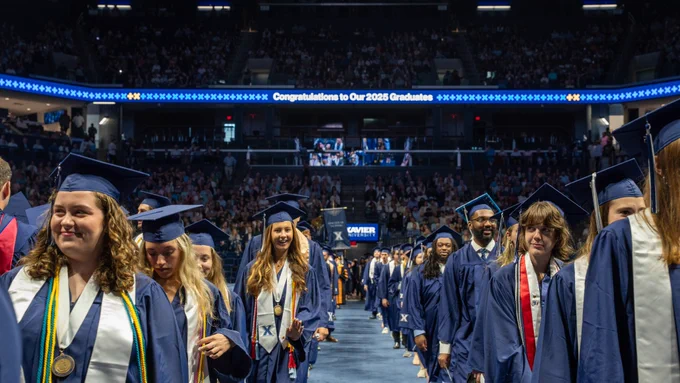 students processing in two lines down the aisle 