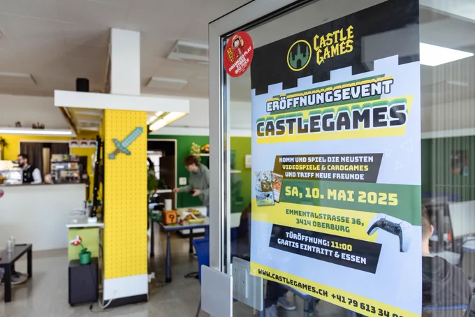 Photo of the entryway to CastleGames in Oberburg, Switzerland with a large "Re-Opening" poster on the door to the right.