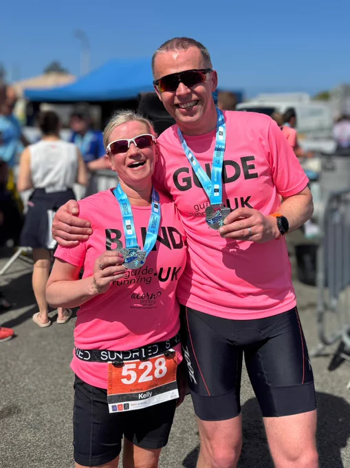 Kelly and Mike holding their finisher medals