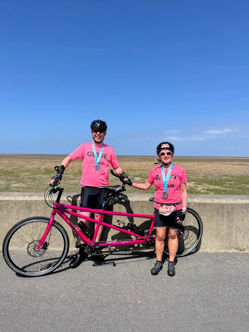 Kelly and Mike in front of their bright pink tandem