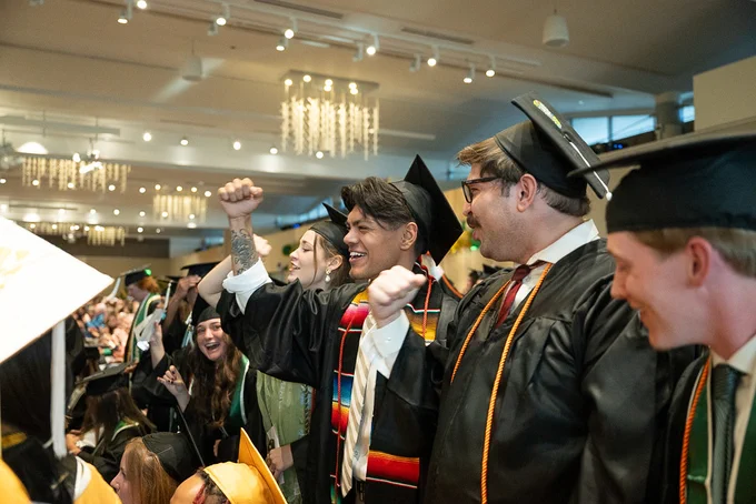 Graduating students celebrating during a recognition ceremony in the L S C Ballroom.