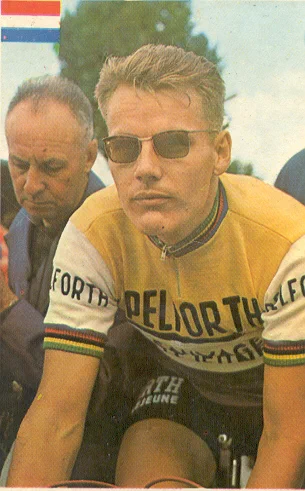Een oude vergeelde foto van Jan Janssen in sporttenue en een zonnebril op, ready op z'n fiets.