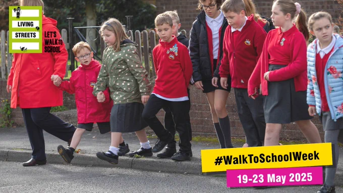 A group of children wearing red school uniforms are poised to cross the road. Text reads: #WalkToSchoolWeek 19-23 May 2025