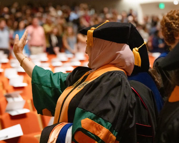A grad waves to supporters