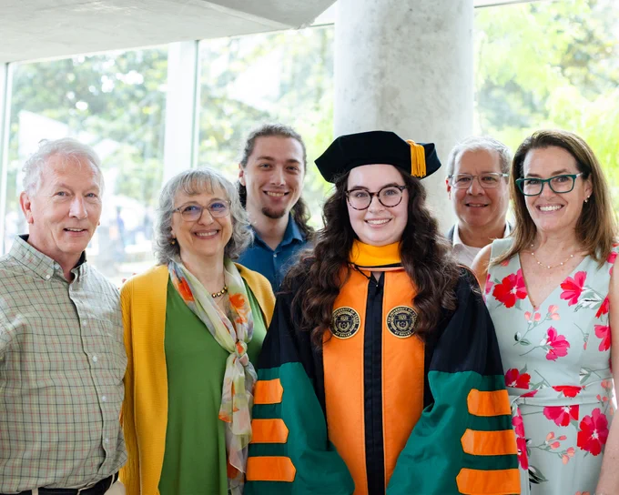 A grad poses with family