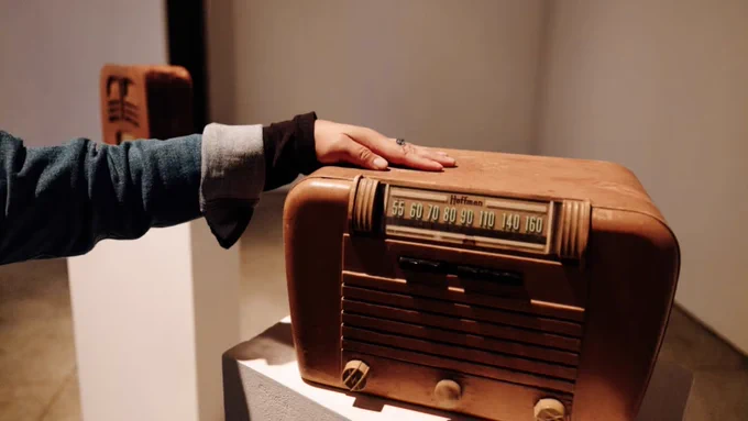 Image of a hand touching a vintage radio that emitted haptic vibrations. Photo by Will Tee Yang