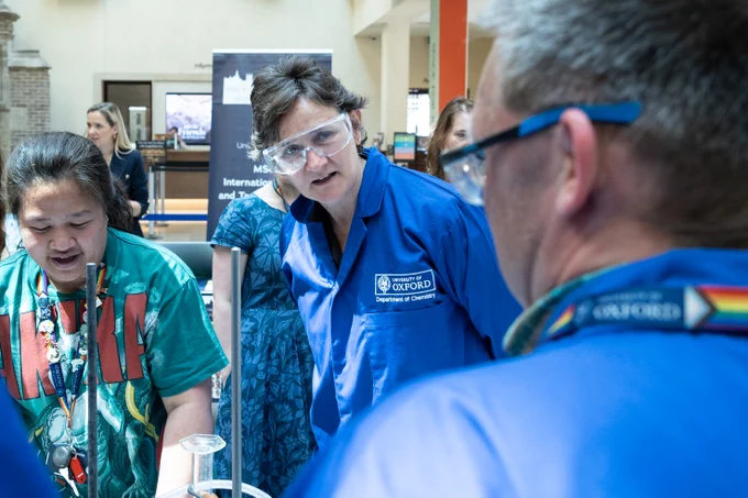 Photograph (c) Cyrus Mower @cyrusoxford 

The Vice-Chancellor in a blue lab coat and safety specs at a stand.