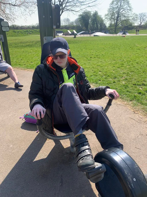 A man using an outdoor piece of gym equipment at a park.