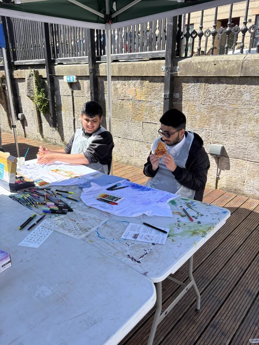 A and A sitting outside eating pizza
