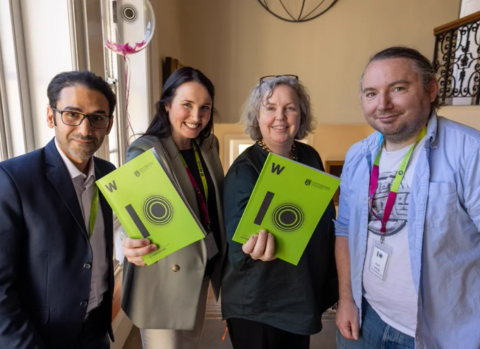 Dr Ali Irannezhad, Administration Officer at TWC, Dr Arlene Gallagher, Director at TWC, Dr Linda Doyle, Provost, Trinity College Dublin, Dr Paul Irving, Community Manager at TWC, holding the 10-year impact report in the School of Physics.