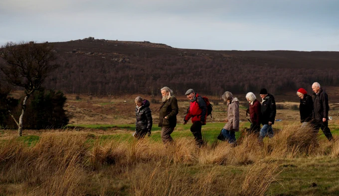 Walkers at Longshaw with hills behind