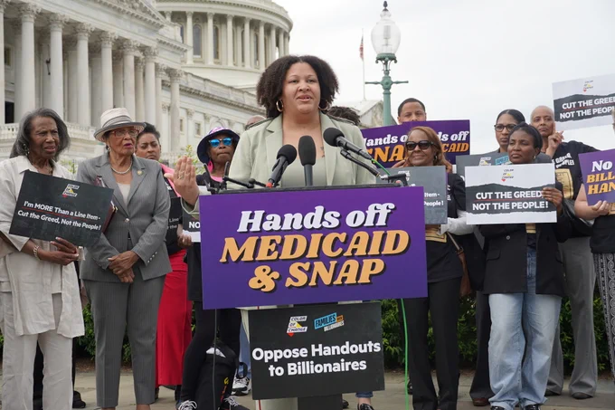 Portia Allen-Kyle stands behind a podium delivering remarks at a press conference on saving Medicaid and SNAP from Republican cuts.