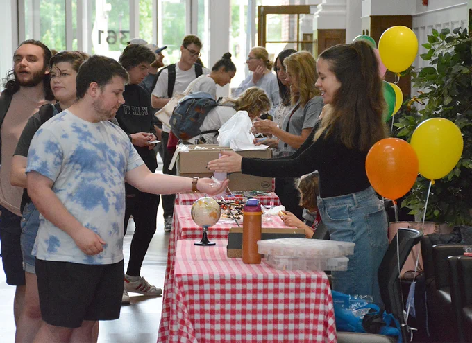 person handing something out at a table