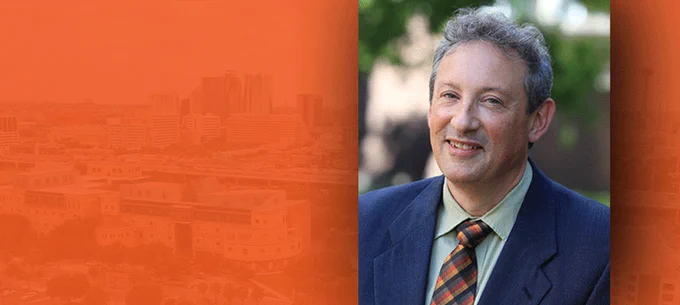 Split image featuring a hazy cityscape on the left and a portrait of Fred Martin on the right.