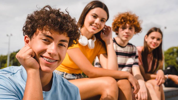 Teenagers sitting on a bench.