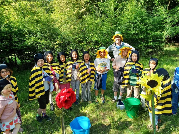 Group of children and adults in bee and flower costumes outdoors!