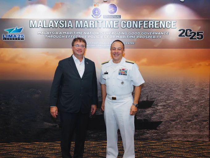 Ambassador Kagan  (left) stands with Rear Admiral Goldhammer in front of the Malaysia Maritime Conference 2025 backdrop at LIMA.
