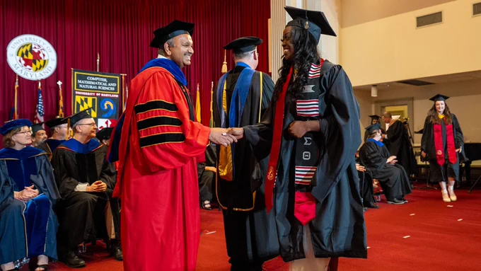 Dean Amitabh Varshney shaking a graduate's hand at the 2024 Graduate Commencement Ceremony