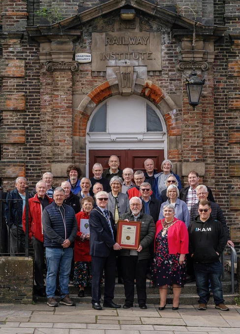 Mr Robert Nicholson (front-left) and outgoing Chair Joan Nicholson (front-right) with volunteers from the Weardale Railway Trust. 
