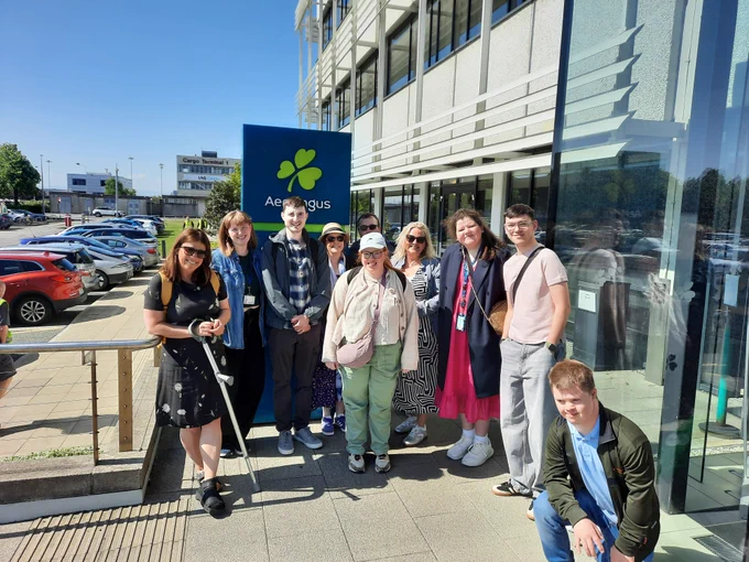 A group of TCPID students and staff standing outside the Aer Lingus building in the beautiful sunshine. 