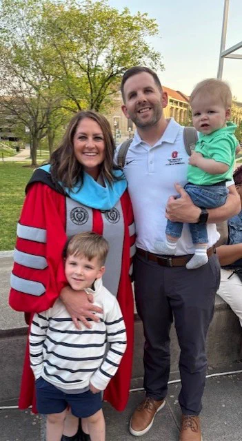 Dr. Ali Williams with her family at her graduation for receiving her Doctorate in Education degree. She is with her husband and two sons. 