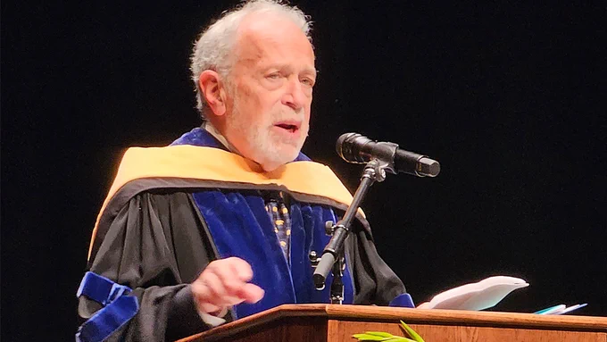 professor emeritus of the goldman school of public policy robert reich standing at the podium delivering the keynote address