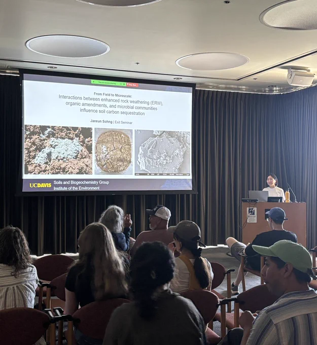 Jaeeun stands at a podium next to the title slide of her presentation.