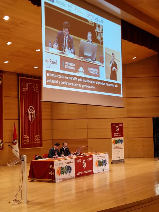 Foto del ponente y el moderador en la mesa durante la intervención.  