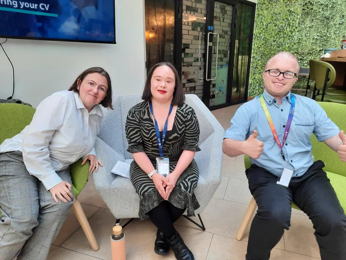 3 TCPID graduates, Marian, Mei Lin and Barry sitting on chairs after finishing a panel discussion. Barry is giving the thumbs up sign