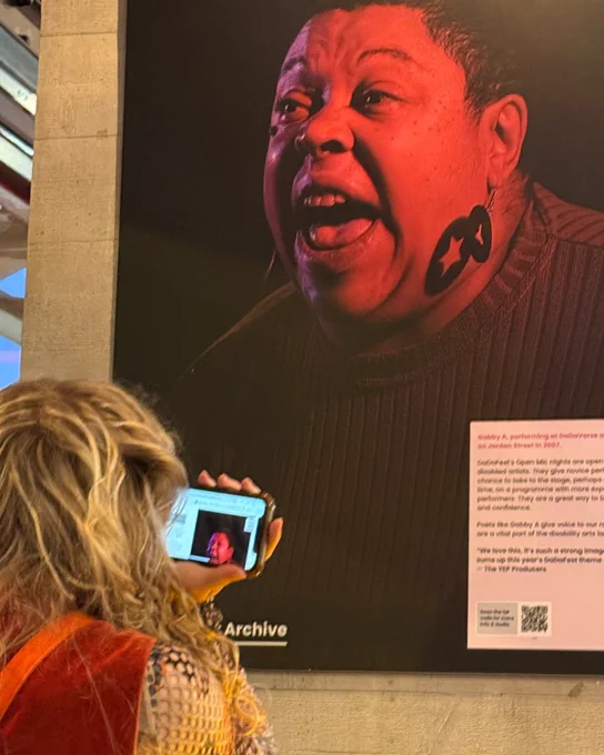 Someone is looking at a large photo displayed on a gallery wall of someone shouting