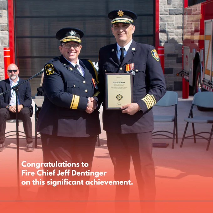 Office Fire Marshal Deputy Fire Marshal Carrie Clark and Hanover Fire Chief Jeff Dentinger shaking hands in front of a fire station, with one receiving a framed certificate. The text congratulates Fire Chief Jeff Dentinger on a significant achievement.