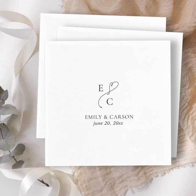 Black and white wedding cocktail napkins featuring a custom monogram with couple’s initials, first names, and wedding date in elegant calligraphy script. A sophisticated and timeless design perfect for receptions and bridal events.